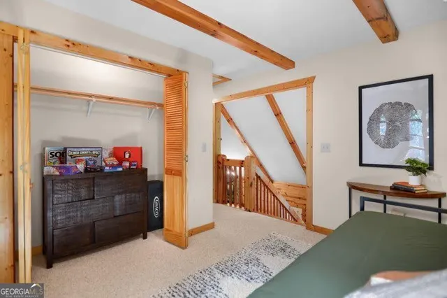 a view of a hallway to room with wooden floor and furniture