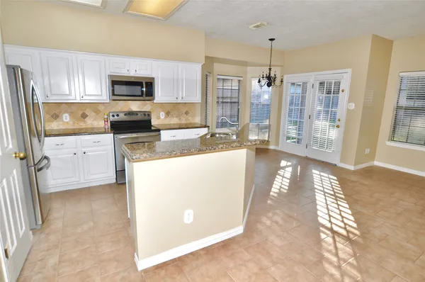 a kitchen with stainless steel appliances granite countertop a refrigerator a stove top oven a sink and dishwasher