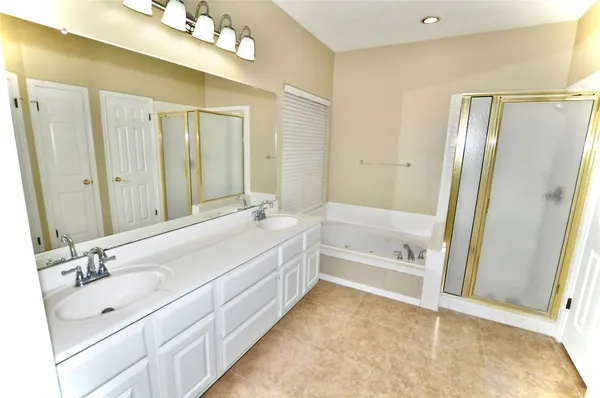 a bathroom with a tub sink and mirror