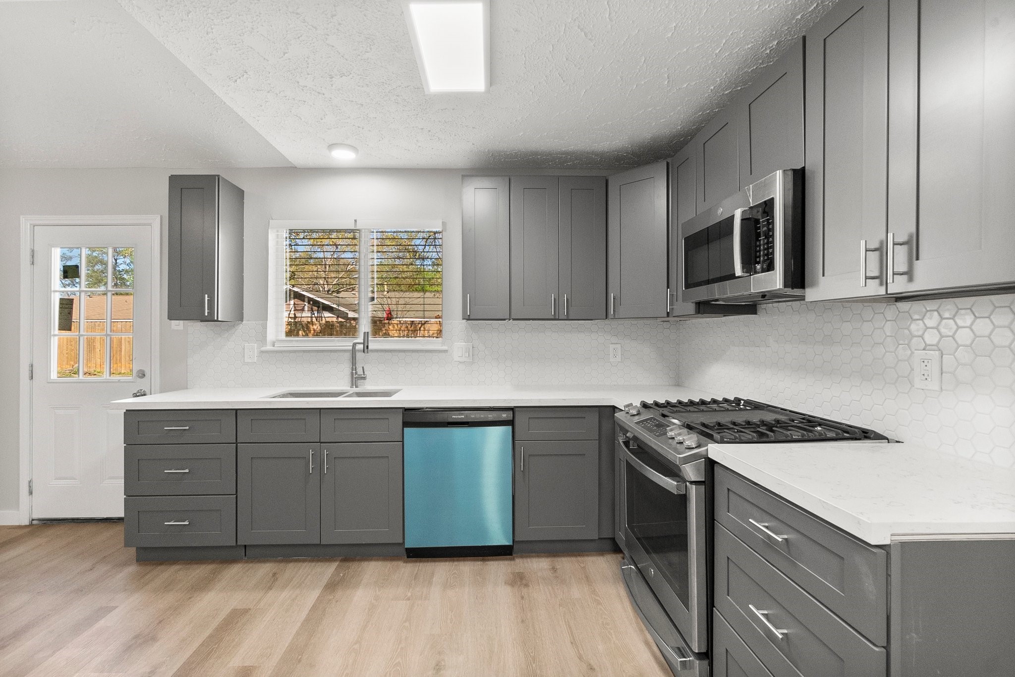 22907 Lemon Grove Drive Spring, TX 77373 - Photo 11 of 30 a kitchen with stainless steel appliances granite countertop a stove a sink and a microwave