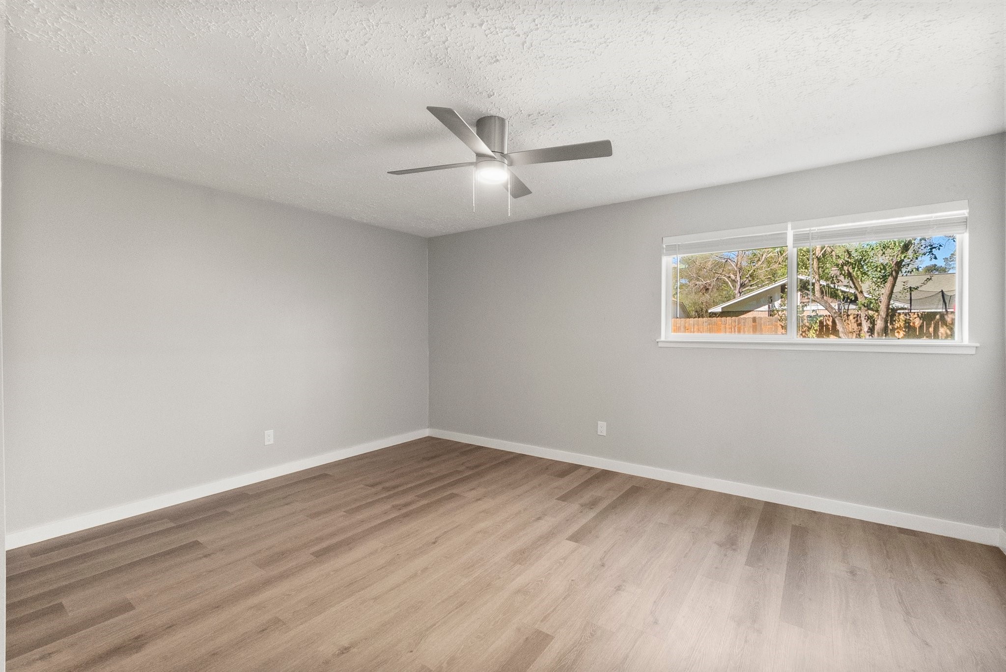 22907 Lemon Grove Drive Spring, TX 77373 - Photo 17 of 30 an empty room with wooden floor and ceiling fan