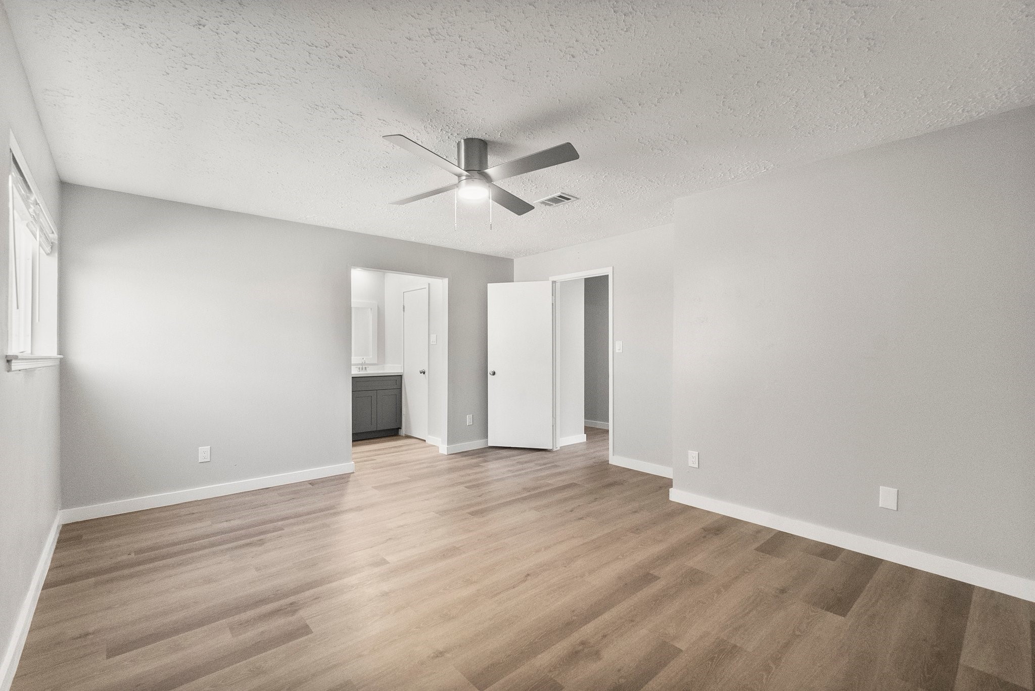 22907 Lemon Grove Drive Spring, TX 77373 - Photo 18 of 30 a view of an empty room with wooden floor and a ceiling fan