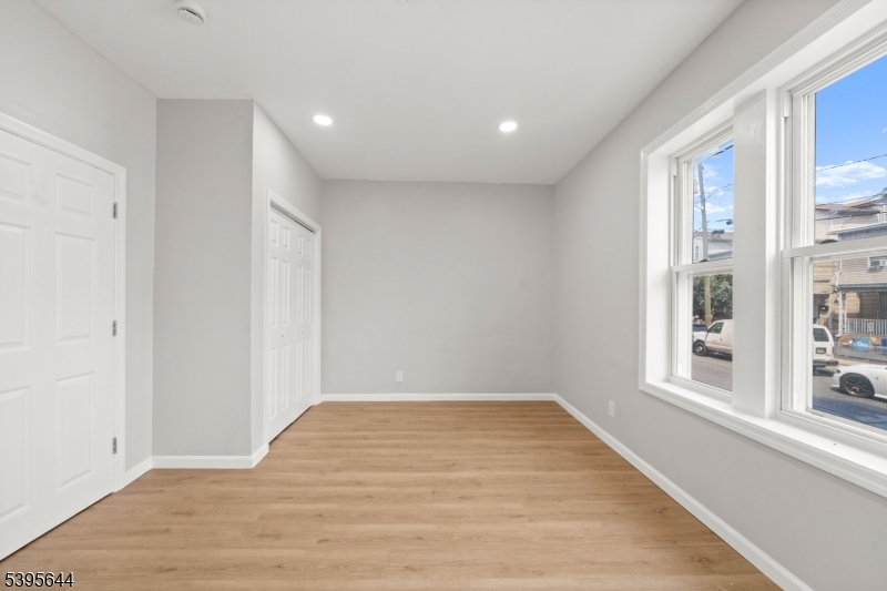 57 Henry Street, Unit A1 Passaic, NJ 07055 - Photo 6 of 14 a view of empty room with wooden floor and fan