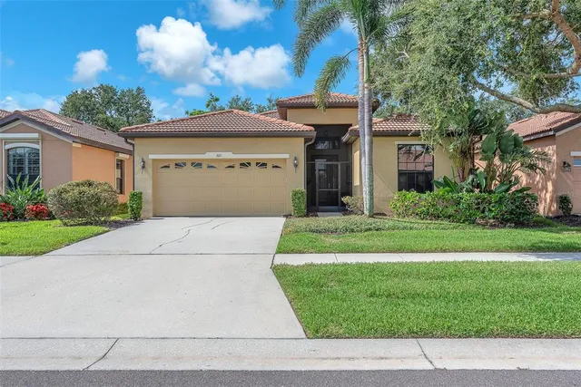 a front view of a house with a yard and potted plants