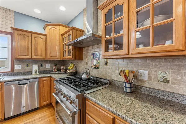 a kitchen with stainless steel appliances granite countertop a stove and a white cabinets