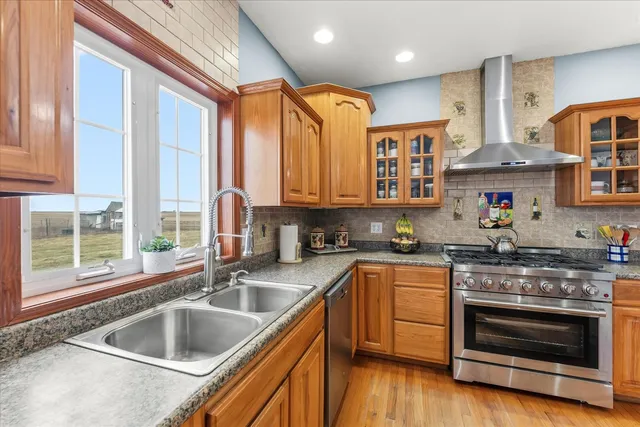 a kitchen with stainless steel appliances granite countertop a sink and wooden cabinets