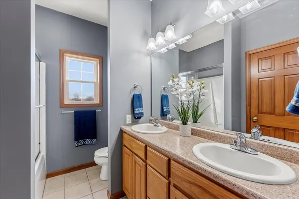 a bathroom with a granite countertop sink a toilet and a mirror