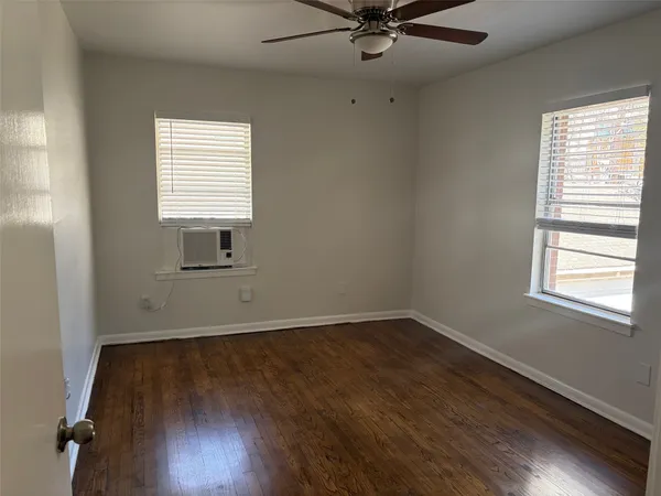 a view of an empty room with wooden floor