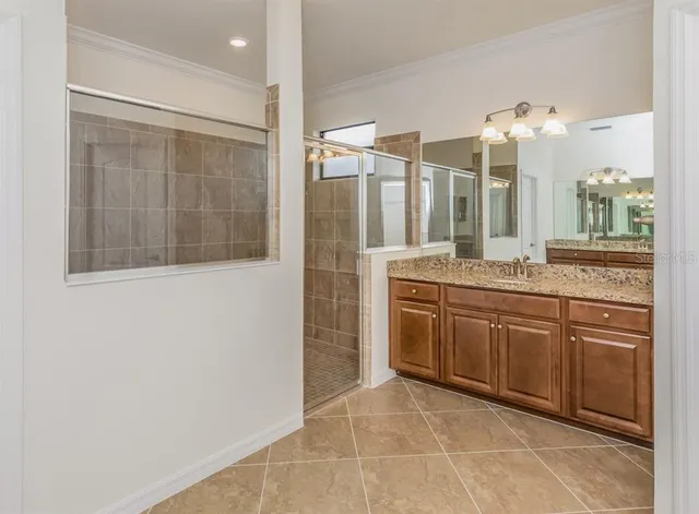 a spacious bathroom with a granite countertop sink a mirror and a shower