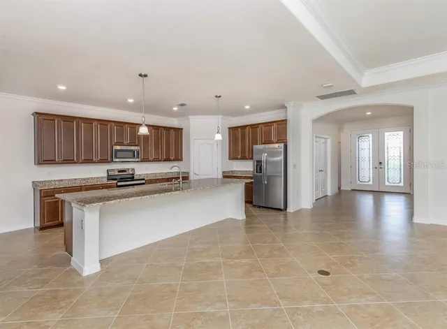 a view of kitchen with kitchen island stainless steel appliances refrigerator sink and cabinets