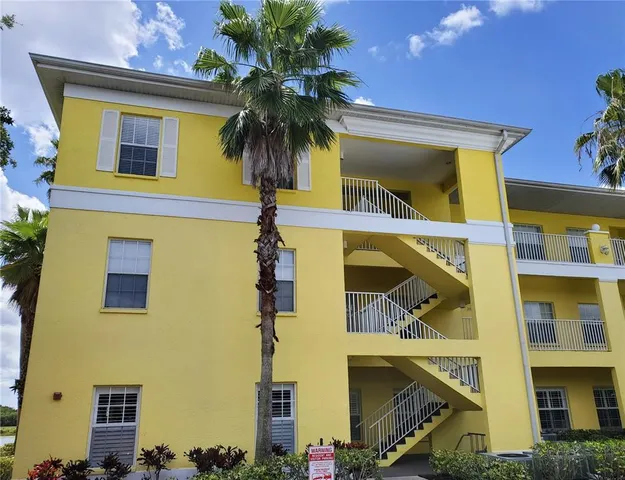 a front view of a building with a palm tree