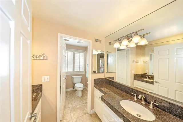 a bathroom with a granite countertop sink mirror and a shower
