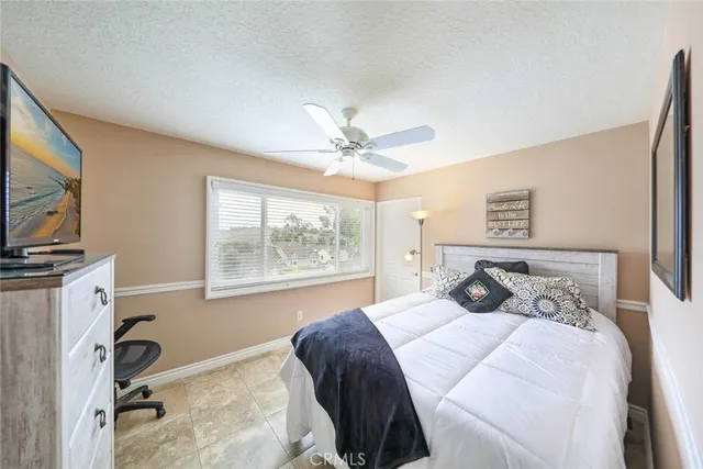 a bedroom with a bed and a flat tv screen on the dresser