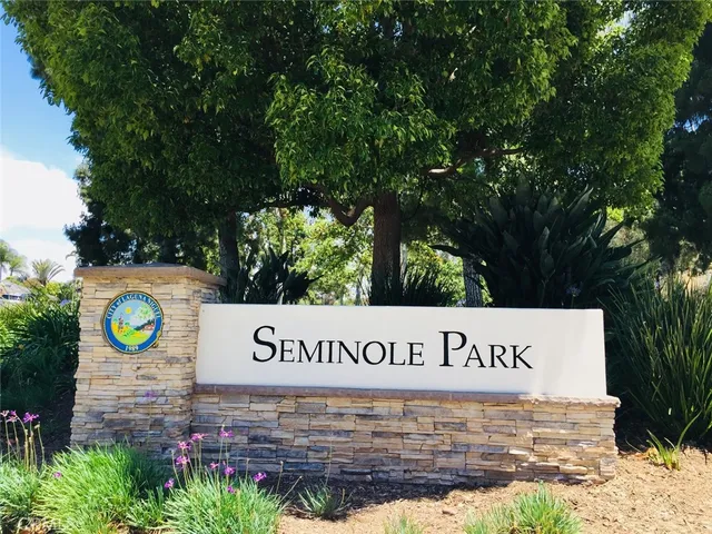 a sign of golf club on a wall under a tree