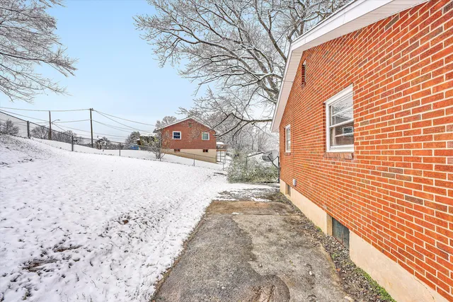 a front view of a house with a yard covered in snow
