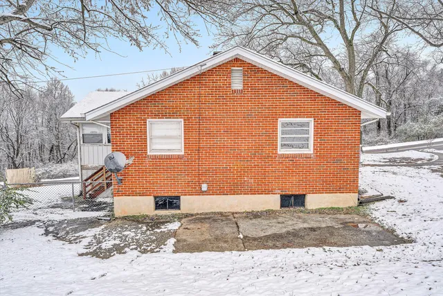 a view of a house with a yard covered in snow