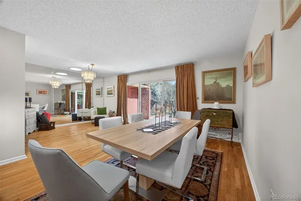 a view of a dining room and livingroom with furniture wooden floor a rug and a chandelier