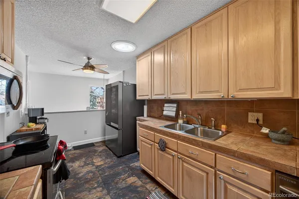 a kitchen with stainless steel appliances granite countertop a sink refrigerator and cabinets