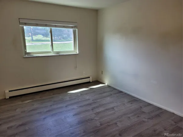 an empty room with wooden floor and a window