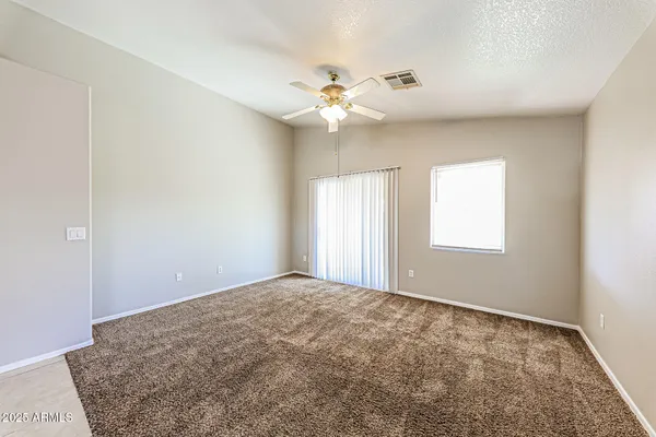 a view of a livingroom with a window and a chandelier fan