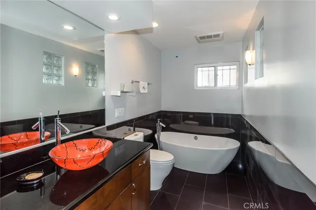 a bathroom with a sink a toilet and a mirror