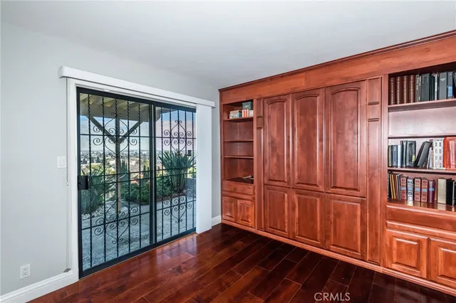 an empty room with wooden floor book shelves