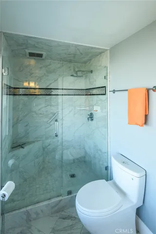 a bathroom with a toilet and a shower