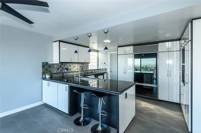 a kitchen with stainless steel appliances granite countertop a sink and a refrigerator