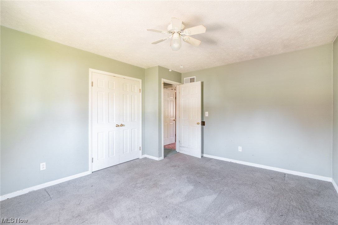 6038 Tippecanoe Road Canfield, OH 44406 - Photo 18 of 34 Unfurnished bedroom featuring a closet, ceiling fan, and light colored carpet