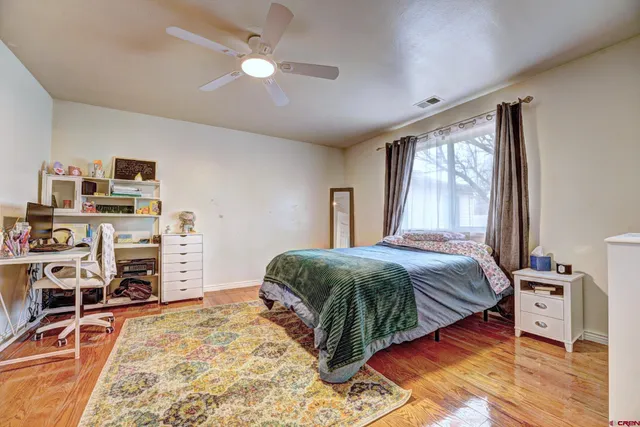 a bedroom with a bed and a flat tv screen on the dresser