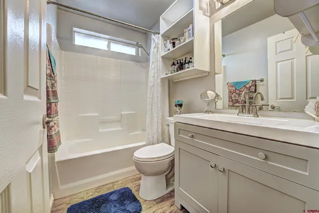 a bathroom with a sink a mirror a toilet and bathtub