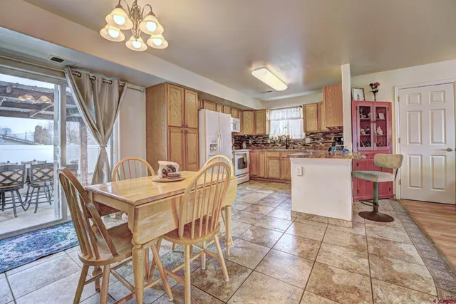 a view of a dining room with furniture and a chandelier