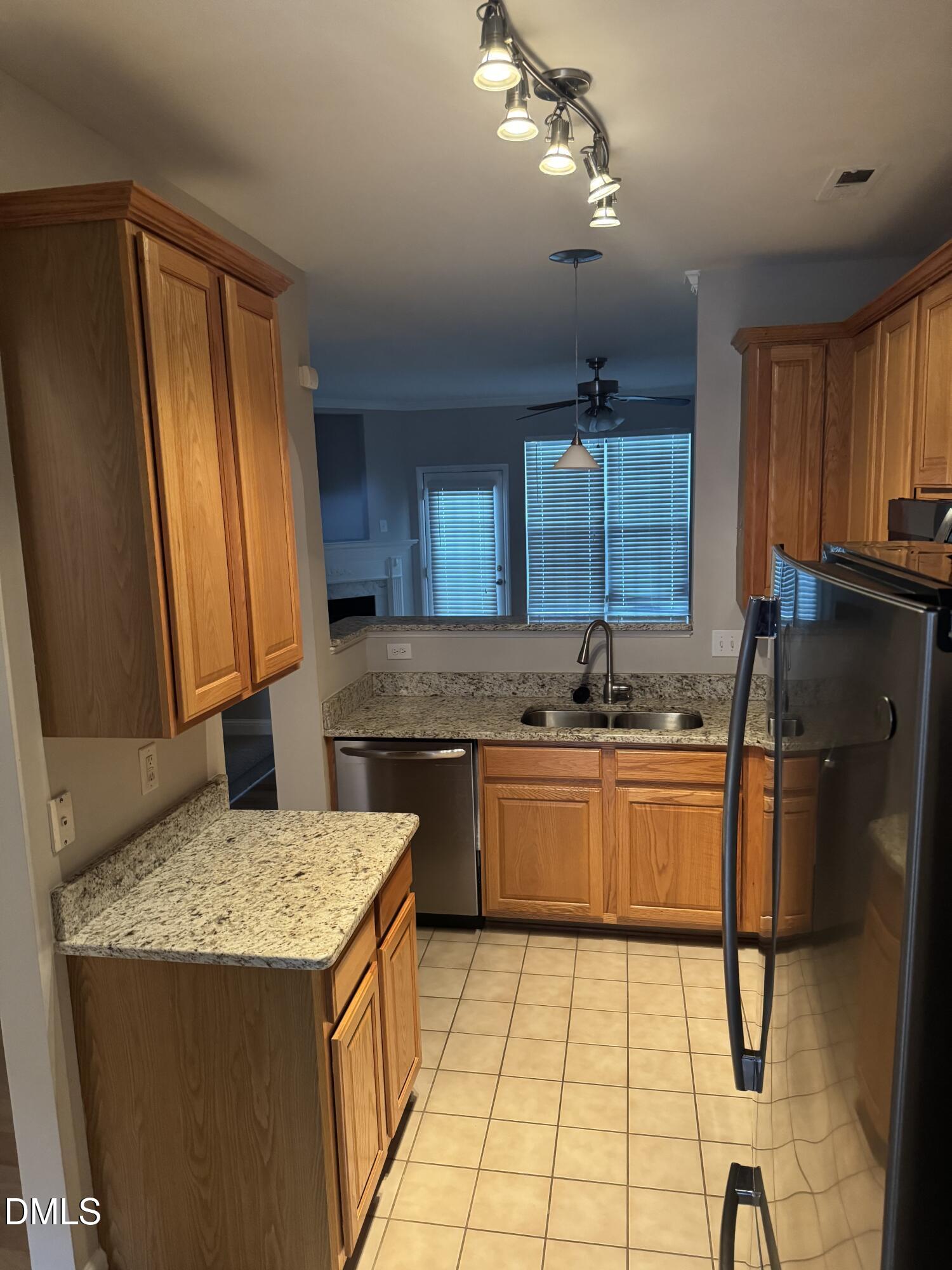 5743 Corbon Crest Lane Raleigh, NC 27612 - Photo 5 of 13 a kitchen with stainless steel appliances granite countertop a sink refrigerator and cabinets