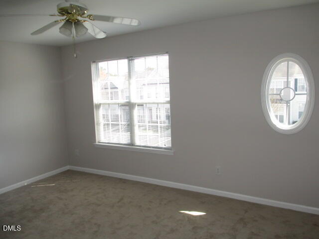 5743 Corbon Crest Lane Raleigh, NC 27612 - Photo 7 of 13 an empty room with windows and chandelier fan