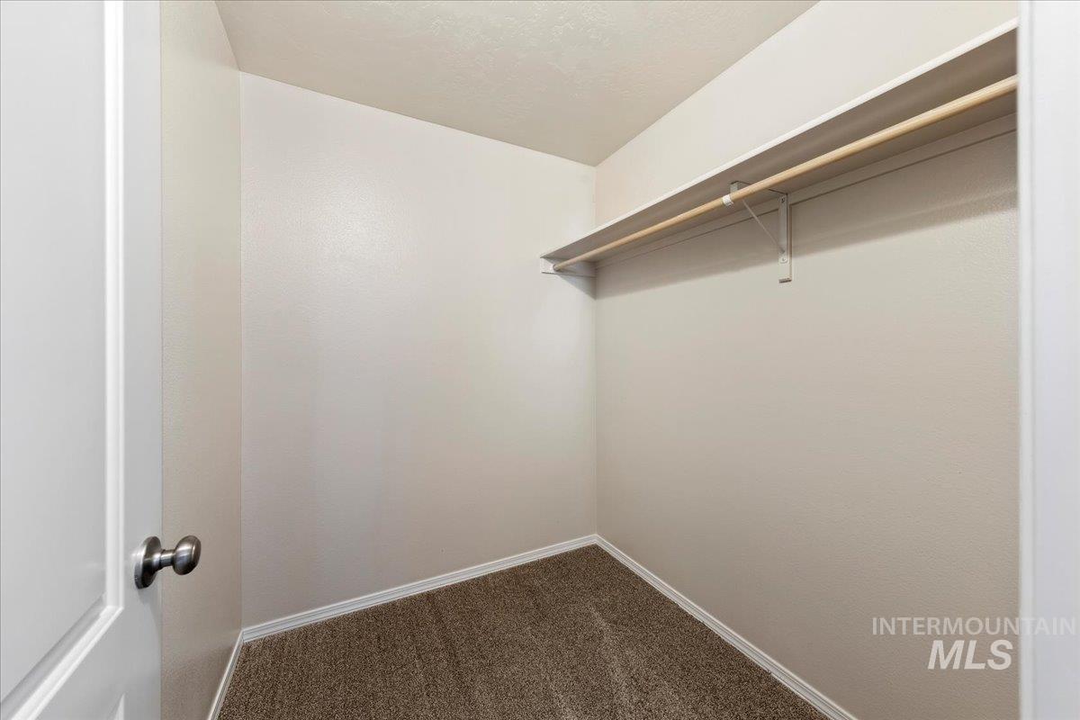 1555 Condor Drive Middleton, ID 83644 - Photo 39 of 50 Walk-in closet featuring carpet flooring, crisp white walls, a built-in shelf, and a hanging rod