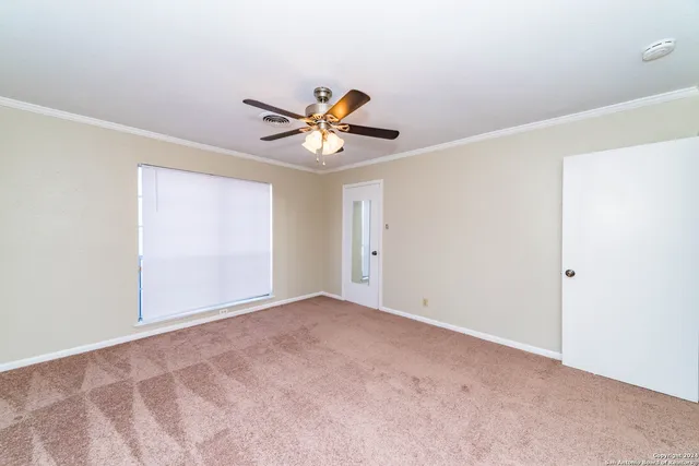 an empty room with a window and a ceiling fan