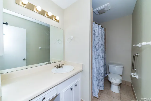 a bathroom with a granite countertop toilet a sink and a mirror