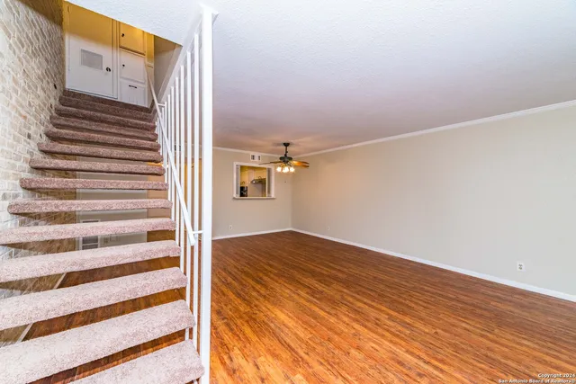a view of a room with wooden floor and white walls