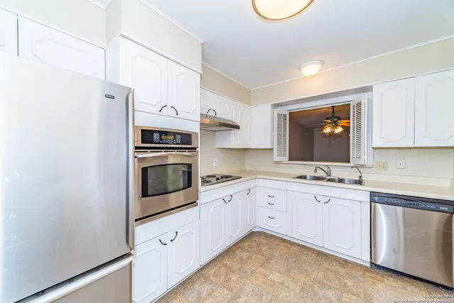 a kitchen with stainless steel appliances a sink stove and cabinets