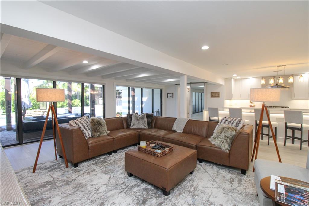 1555 Crayton Road Naples, FL 34102 - Photo 11 of 50 Living room featuring beamed ceiling, light hardwood / wood-style flooring, and a notable chandelier