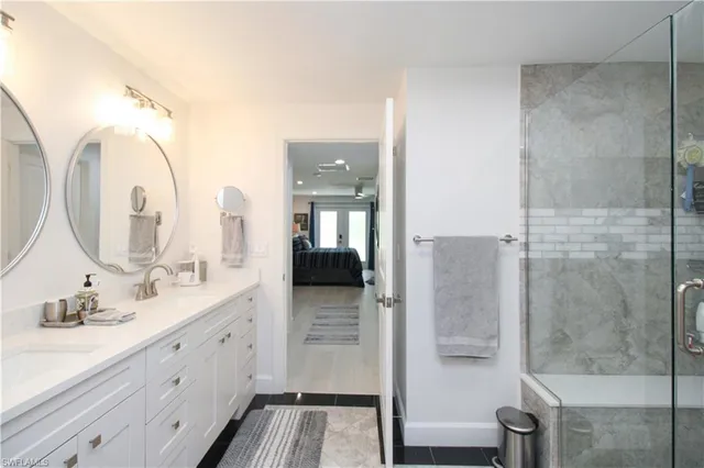 a bathroom with a double vanity sink mirror and shower