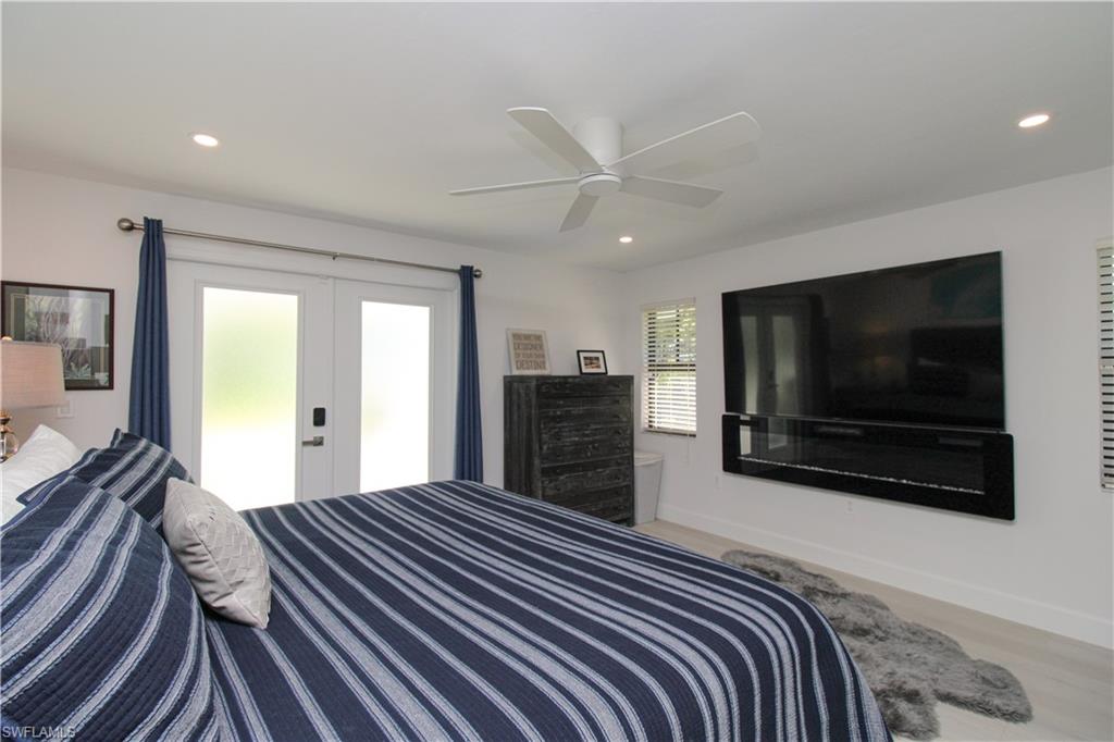 1555 Crayton Road Naples, FL 34102 - Photo 21 of 50 Bedroom featuring ceiling fan, light wood-type flooring, and french doors