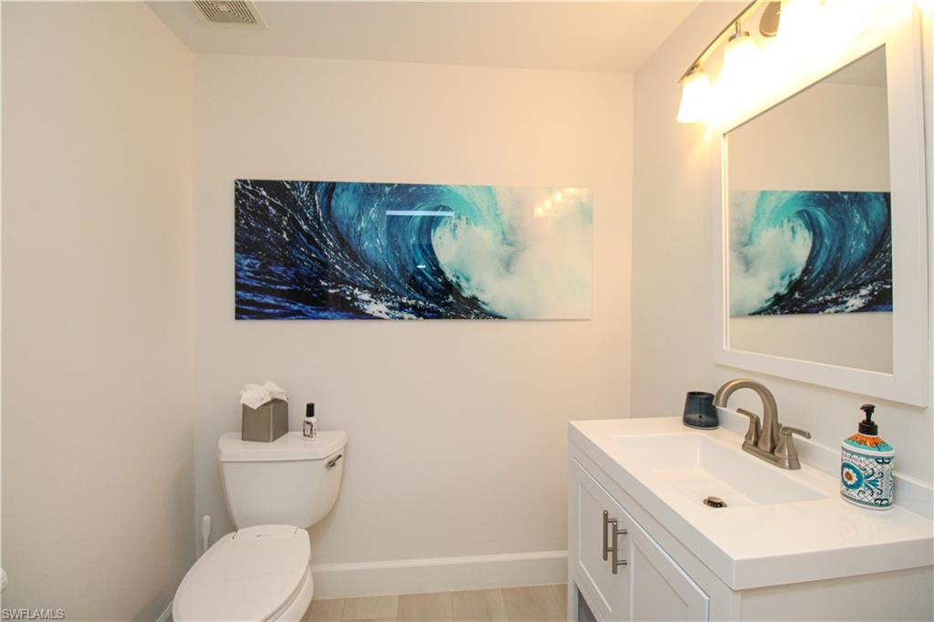 1555 Crayton Road Naples, FL 34102 - Photo 22 of 50 Bathroom featuring vanity, hardwood / wood-style flooring, and toilet