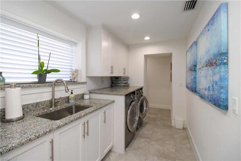 1555 Crayton Road Naples, FL 34102 - Photo 23 of 50 Laundry room with separate washer and dryer, sink, light tile patterned flooring, and cabinets