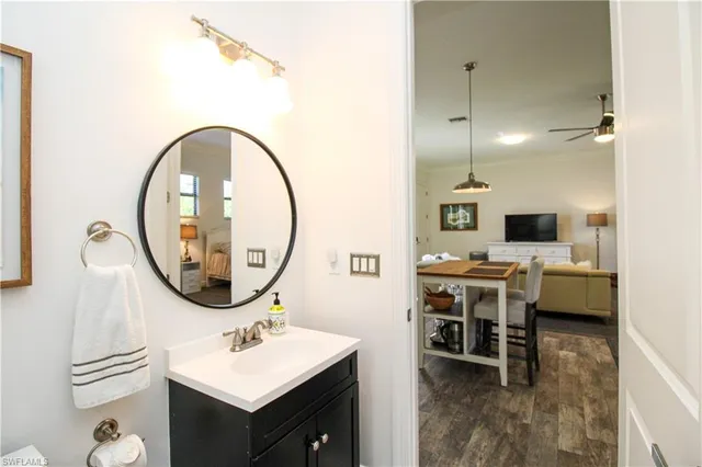 a bathroom with a sink a mirror and a painting on the wall