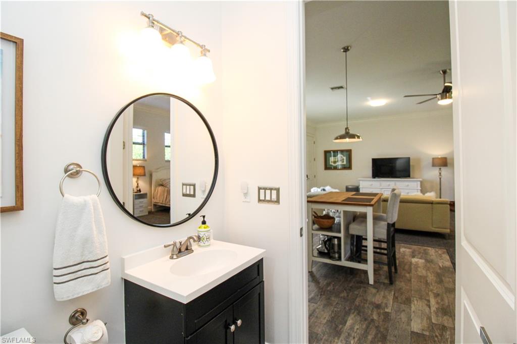 1555 Crayton Road Naples, FL 34102 - Photo 27 of 50 Bathroom featuring hardwood / wood-style floors, ceiling fan, ornamental molding, and vanity