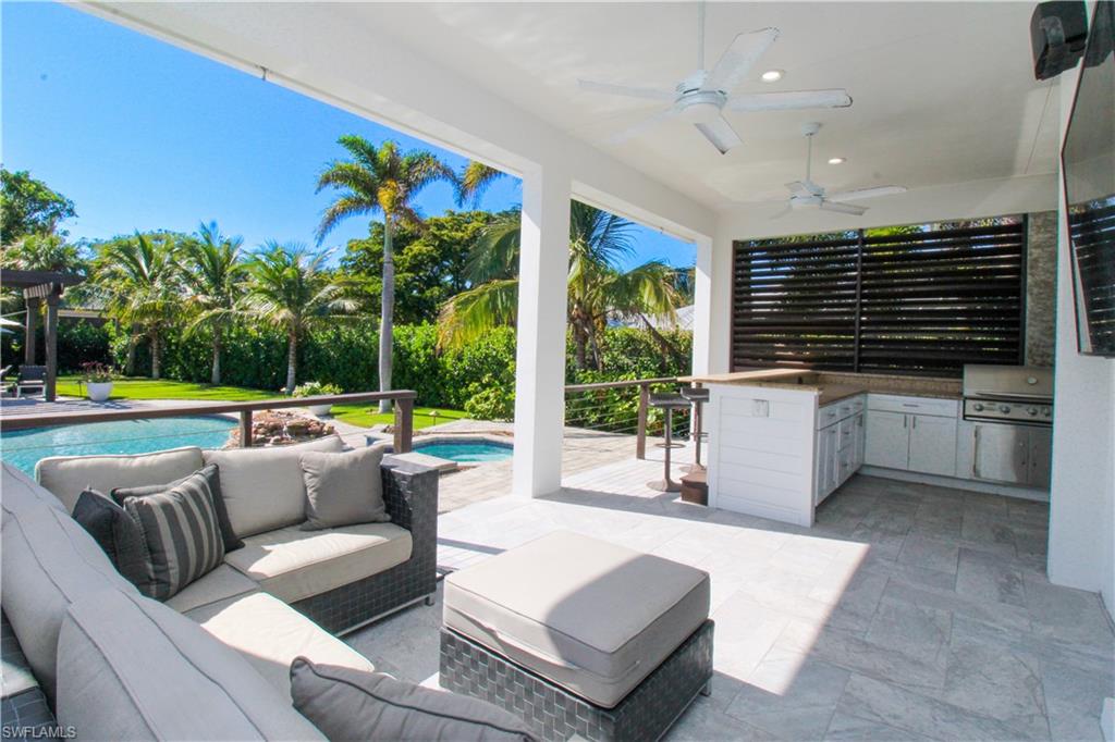 1555 Crayton Road Naples, FL 34102 - Photo 32 of 50 View of patio featuring outdoor lounge area, ceiling fan, exterior kitchen, a hot tub, and area for grilling