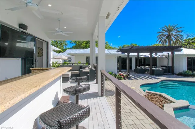 a living room with furniture a flat screen tv and a floor to ceiling window