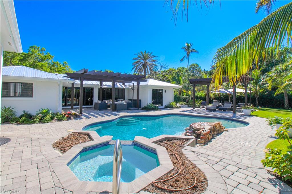 1555 Crayton Road Naples, FL 34102 - Photo 38 of 50 View of pool with an in ground hot tub, an outdoor living space, a pergola, and a patio