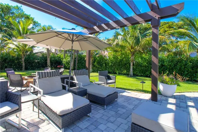 a view of a patio with a table and chairs under an umbrella